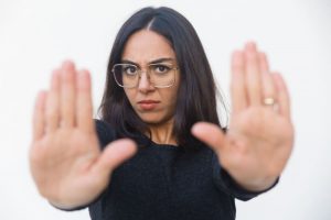 seorang wanita memberi tanda menolak ke rekan kerjanya