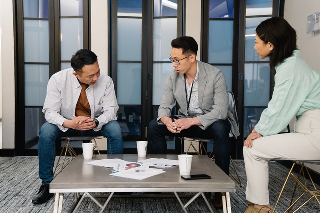 3 orang asia sedang berdiskusi untuk membuat produk yang berkualitas