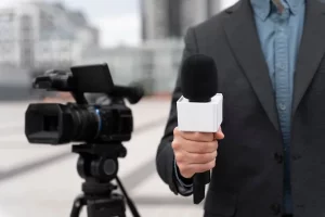tangan seorang wartawan memegang mikrofon