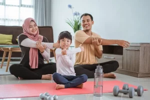 ibu, bapak, dan anak sedang melakukan teknik relaksasi otot